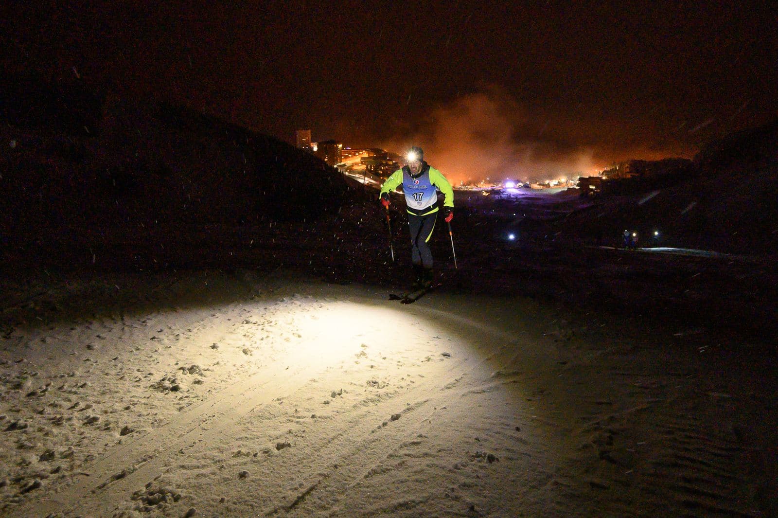 Skieur de randonnée à la frontale dans la nuit