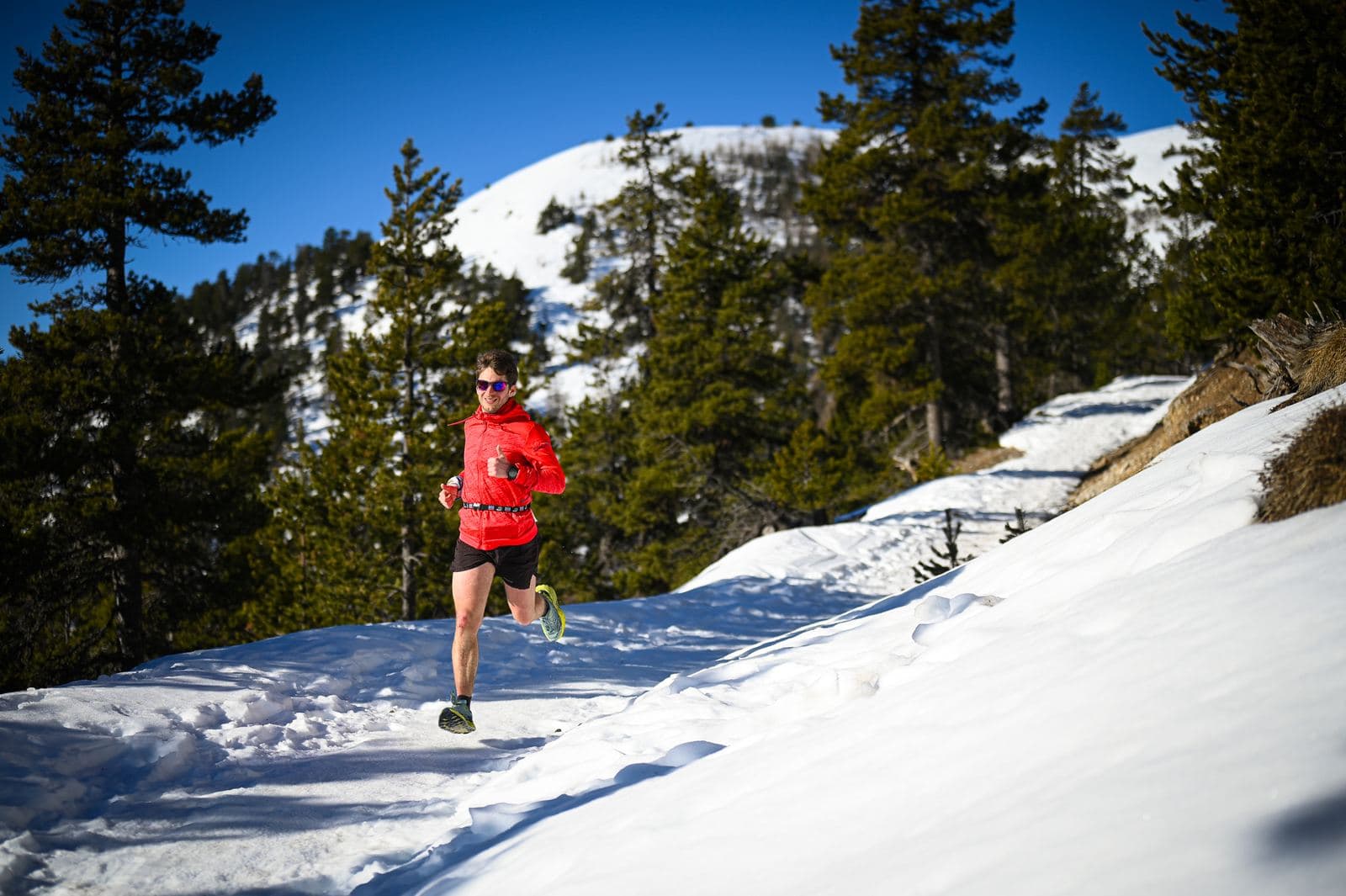 Corritrice in rosso su un sentiero innevato nel bosco