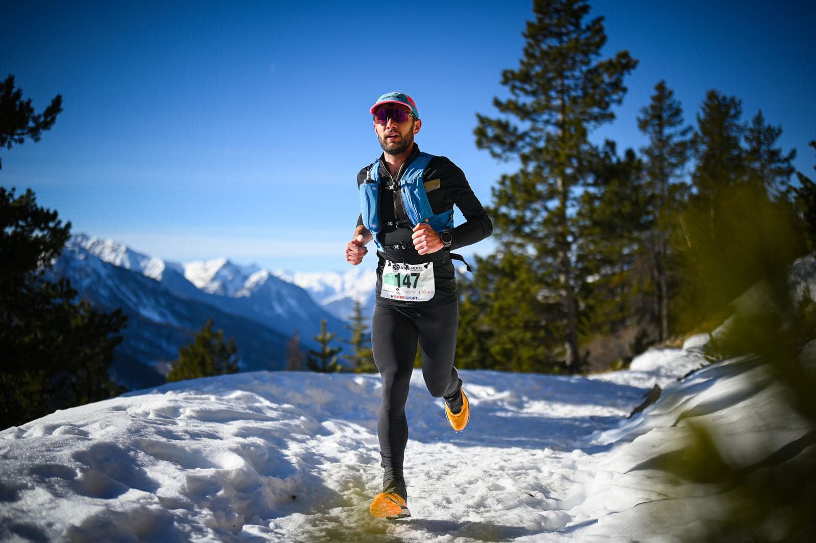 Coureur sur la neige, montagnes enneigées en fond
