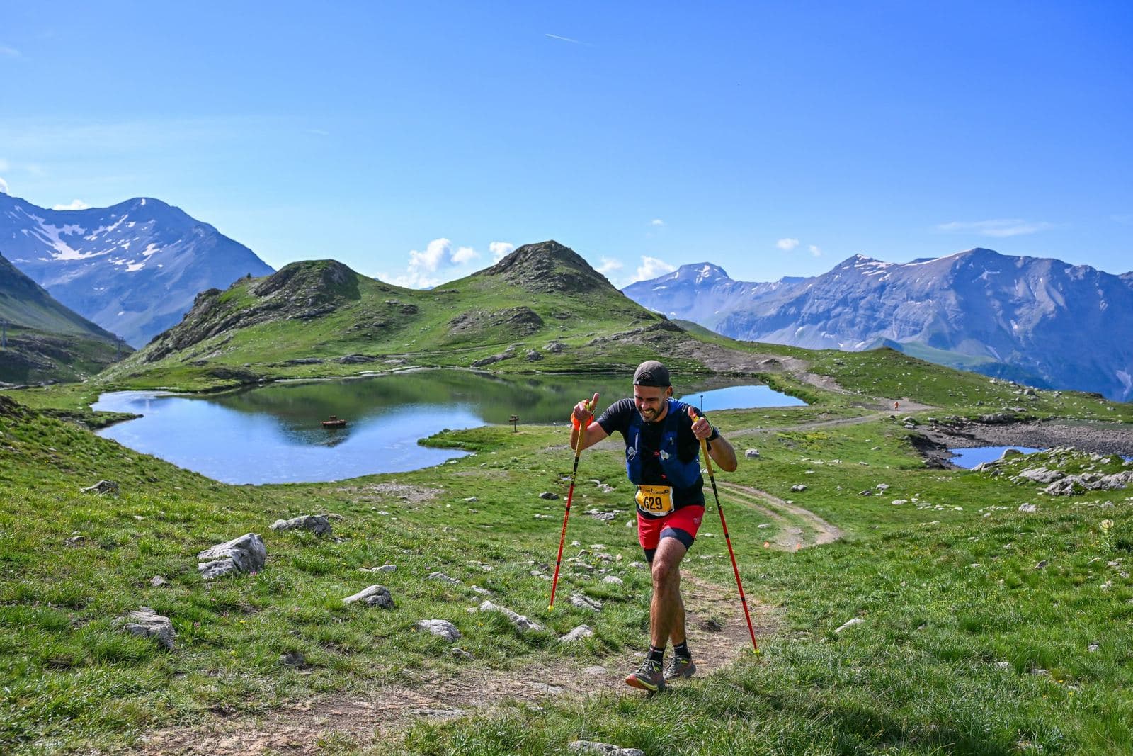 Coureur avec bâtons au-dessus de deux lacs d'altitude